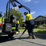 Worker using crack sealing machine on asphalt pavement in residential area